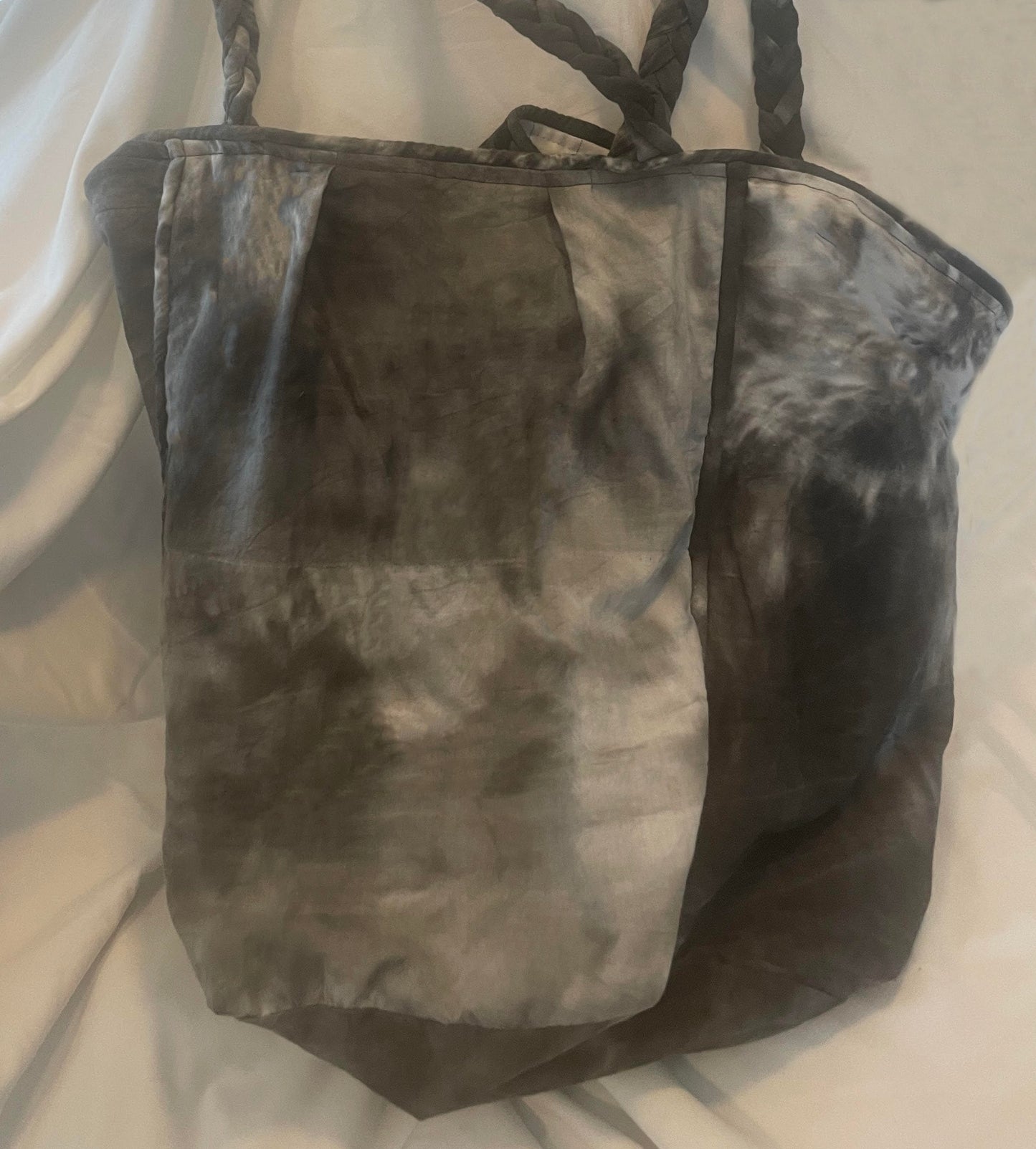 Side profile of the Tie Dy Leigh Bag showing its slouchy silhouette, piped binding detail, and soft structure crafted from repurposed cotton fabric.