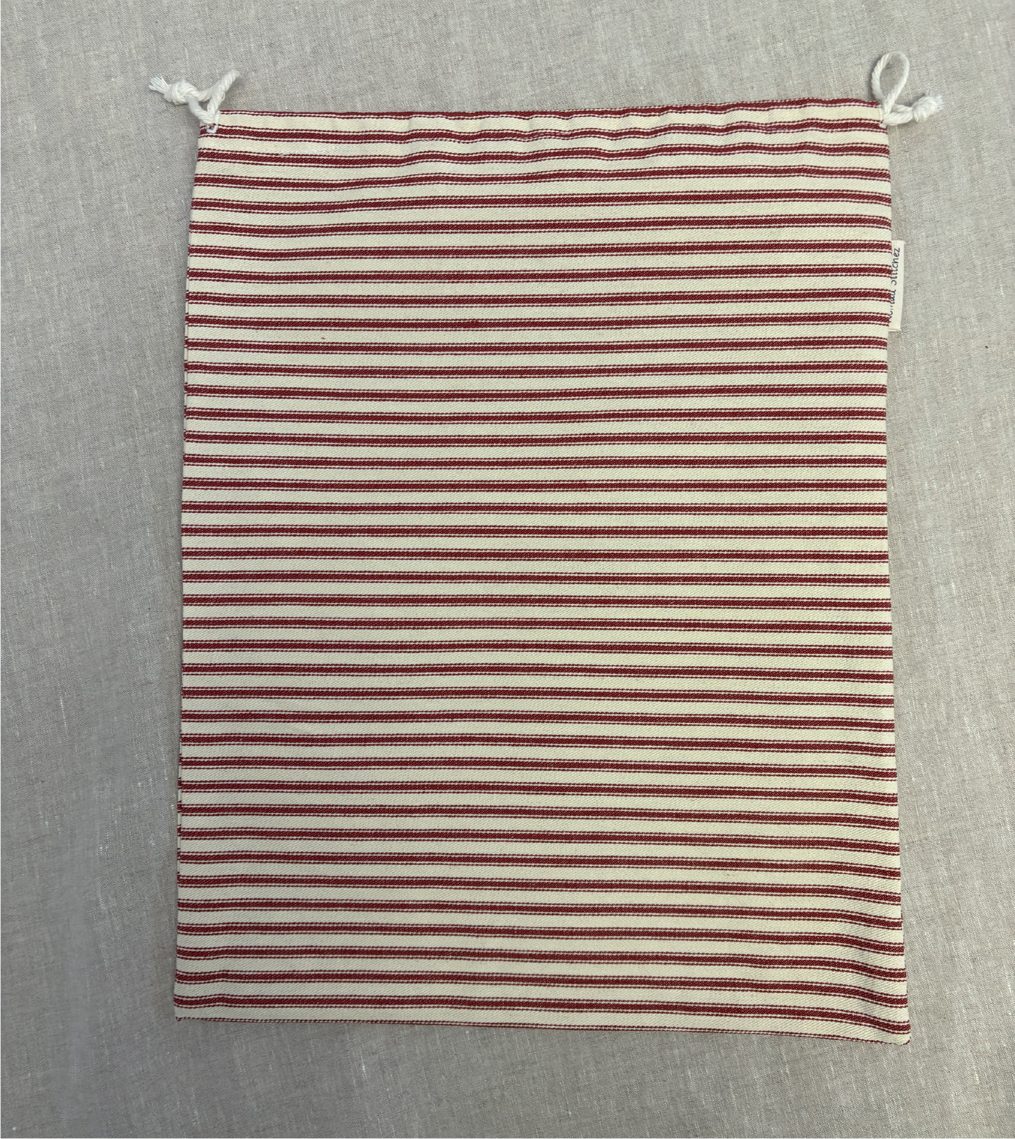 Horizontal red stripe cotton utility bag with a cotton drawstring closure, 12in x 15in size, part of the Essentials Collection.