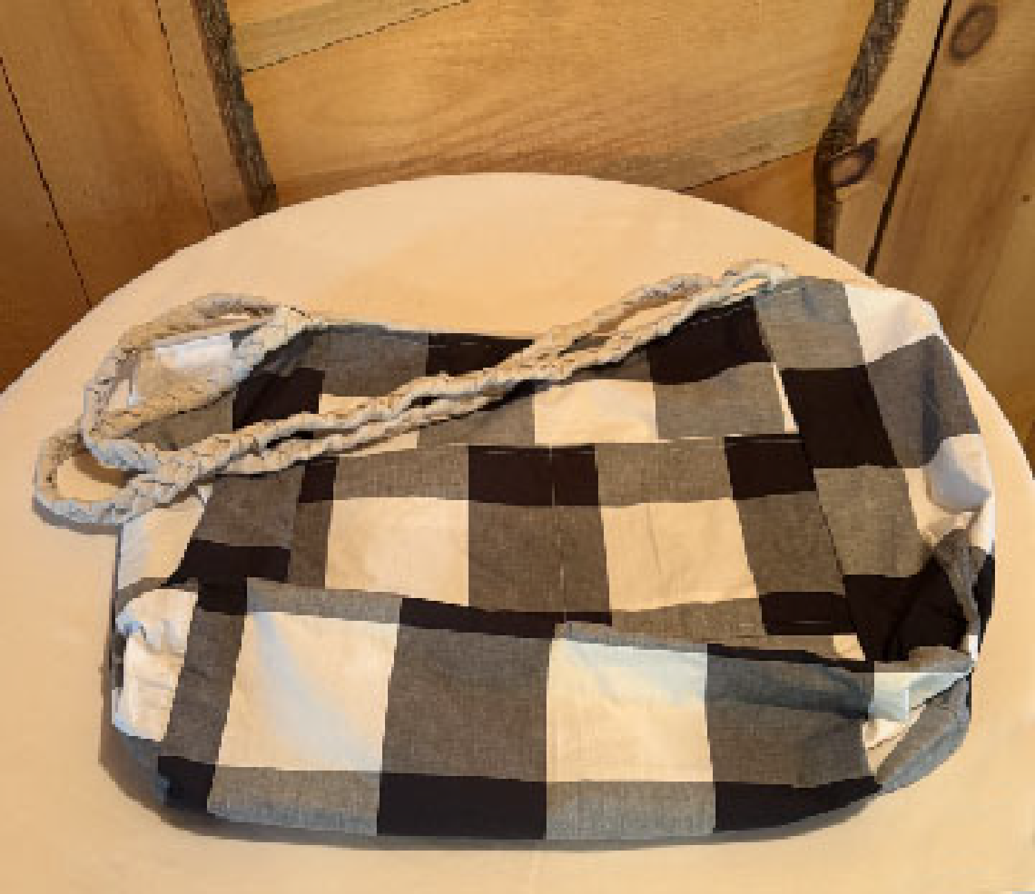 Interior of the Leigh Bag featuring a black-and-white buffalo check cotton lining with organized pockets.