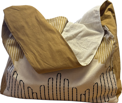 Mustard and black printed sling bag with a solid mustard yellow strap and natural cotton muslin lining.