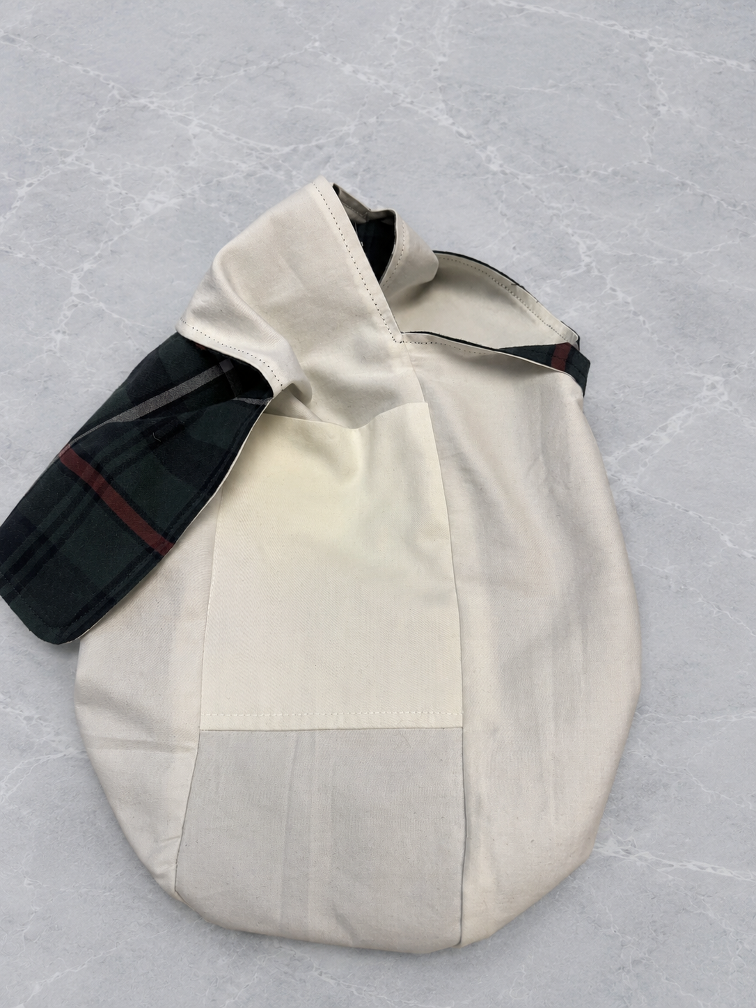 Pocket view of the Half-Pint Stitch Bag showing the navy plaid cotton shell, soft solid cotton lining, and interior storage pocket with handcrafted stitching details.