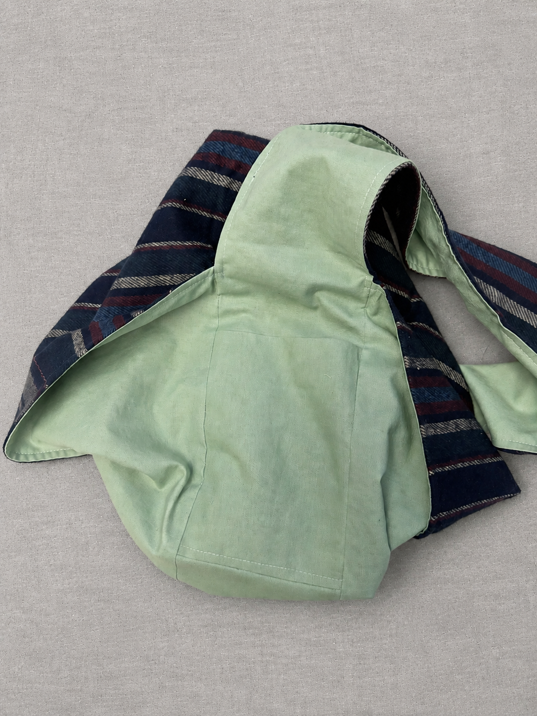 Interior pocket view of the Harbor Mint 1/2 Pint Stitch Bag featuring a soft mint green lining with two internal pockets positioned on either side of the strap attachment for organized everyday storage.