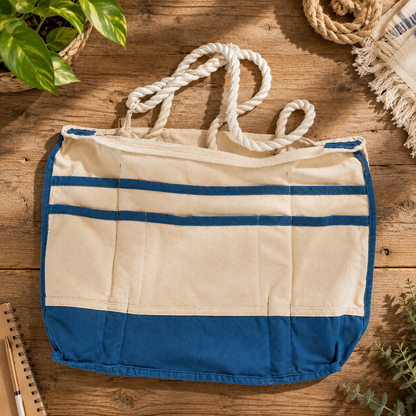 “Interior pocket view of a cotton canvas tote bag trimmed with deep teal waxed canvas, featuring multiple organizational pockets and thick white rope handles within an open structured interior.”