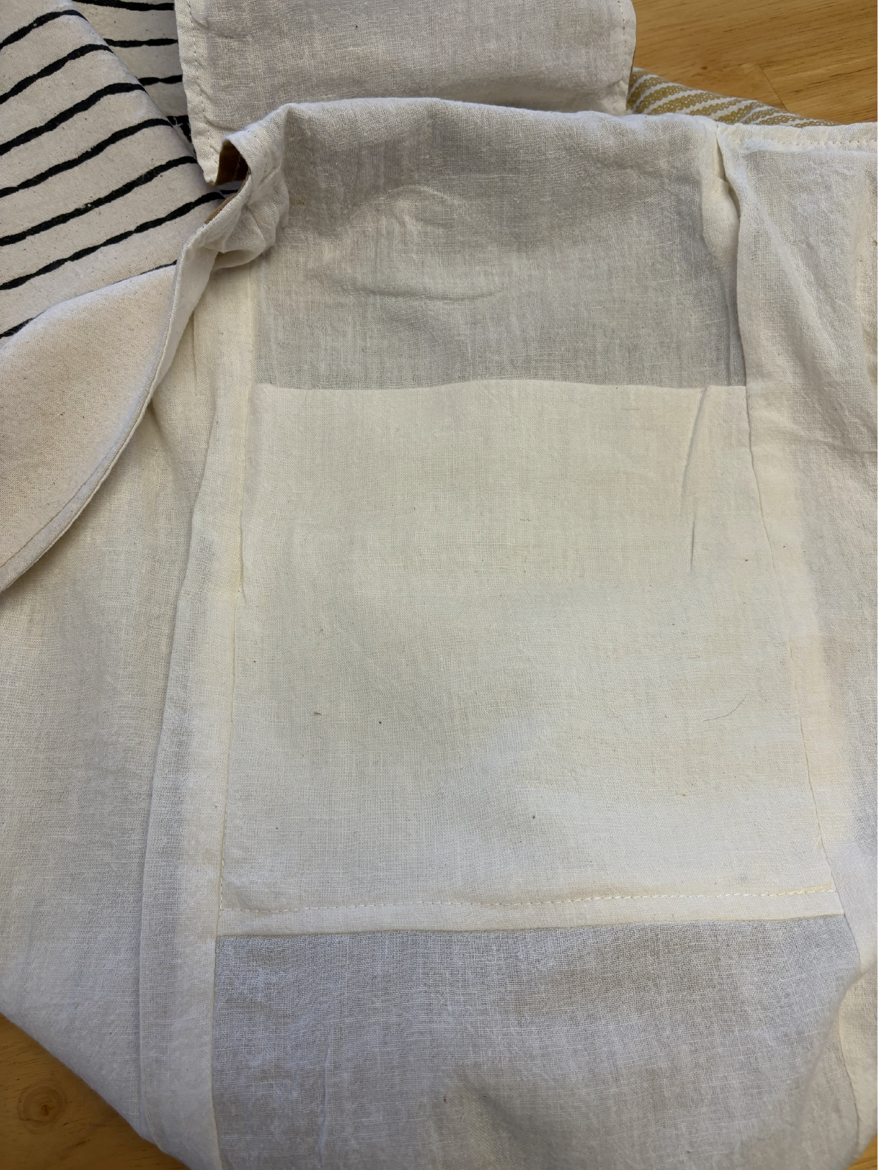Interior of the sling bag displaying natural cotton muslin lining and built-in strap pockets.