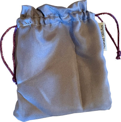 Lavender silk satchel with a soft sheen, featuring a drawstring closure—ideal for holding crystals, jewelry, or small keepsakes.