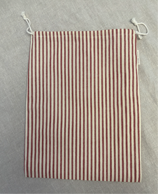 Vertical red stripe cotton utility bag with a cotton drawstring closure, 12in x 15in size, part of the Essentials Collection.