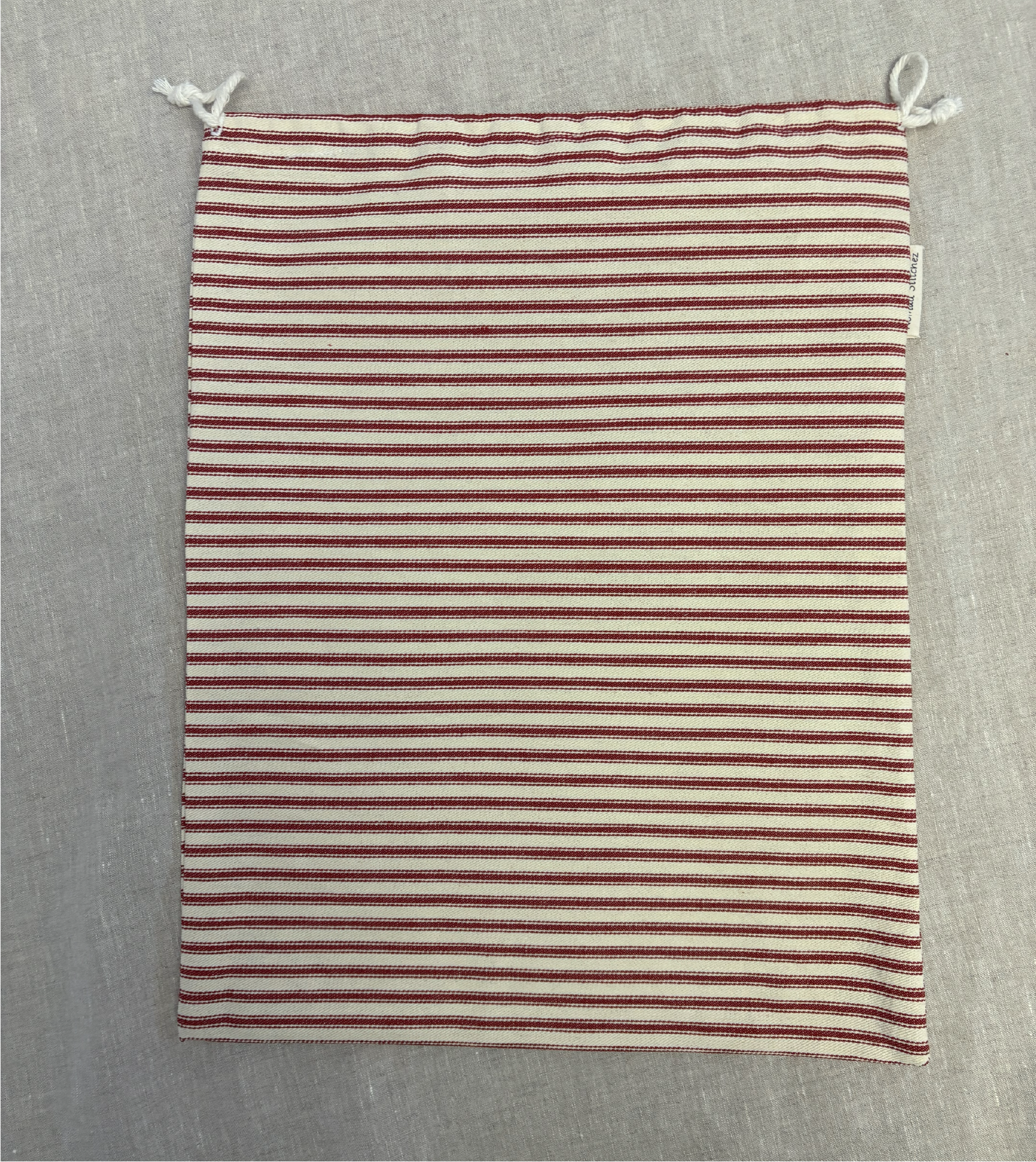 Horizontal red stripe cotton utility bag with a cotton drawstring closure, 12in x 15in size, part of the Essentials Collection.