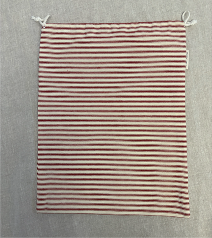 Horizontal red stripe cotton utility bag with a cotton drawstring closure, 12in x 15in size, part of the Essentials Collection.